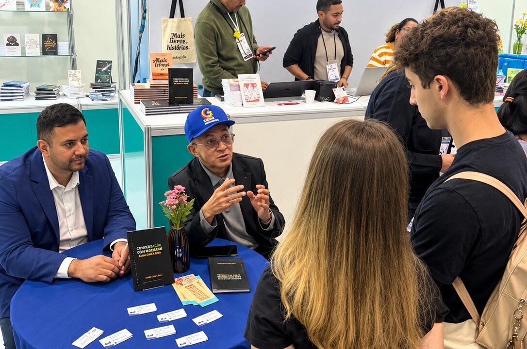 Professor Bibiano Costa de boné azul durante autógrafos na Bienal.